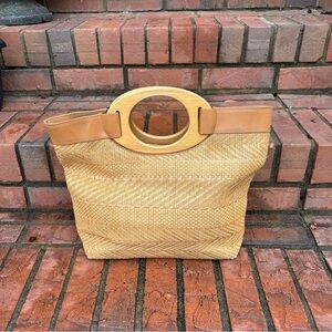 vintage Fossil handbag featuring woven straw body and distinctive wooden handle